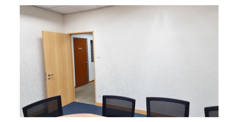 Meeting room with chairs, table, and open door